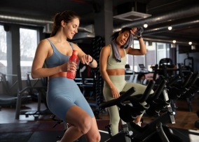Девушки разговаривают в спортзале на велотренажере